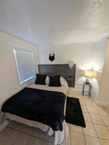 a bedroom with a large bed with a black blanket at Bear cave in Tucson