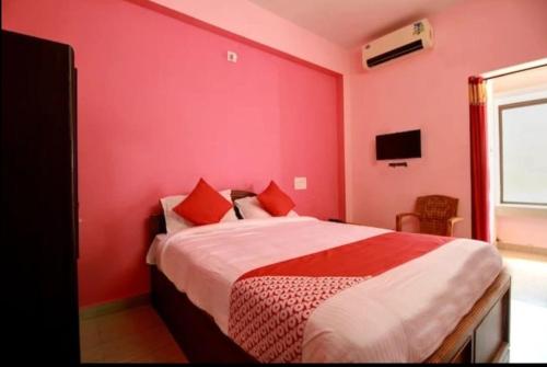 a red bedroom with a large bed with red pillows at Hotel Kalyani International in Mūlki