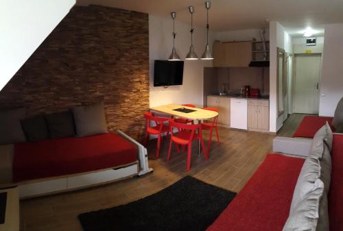 ein Wohnzimmer mit einem Bett und einem Tisch sowie eine Küche in der Unterkunft Apartmani Kopaonik Centar Maglic in Kopaonik