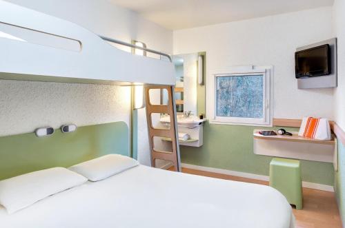 a bedroom with a bed and a bunk bed at ibis Budget Courbevoie Paris La Défense in Courbevoie