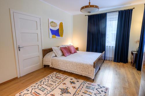 a bedroom with a bed and a door and a rug at Zofija in Birštonas