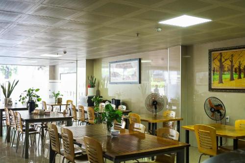 a dining room with wooden tables and chairs at Minh Châu Hotel in Kon Rung (1)