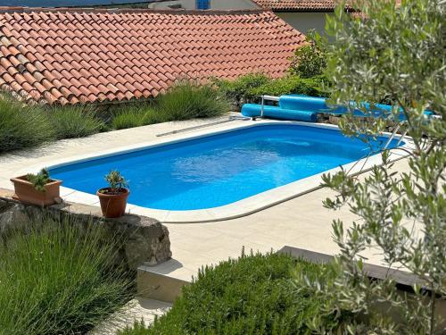 a swimming pool in a yard next to a house at Casa Dorella in peaceful location with a sea view in Viskovići