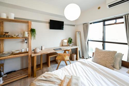 a bedroom with a bed and a desk with a computer at Japandi 4 Inspired 1BR in Prime City Spot and Near Station in Fukuoka