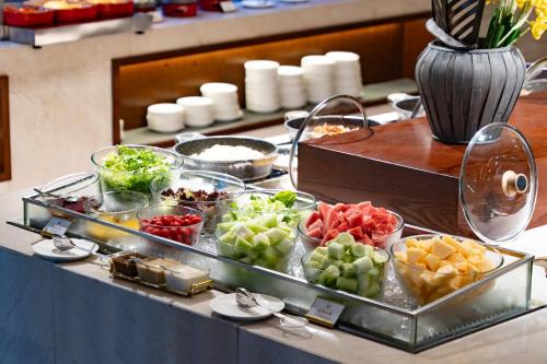 a buffet with different types of fruits and vegetables at SSAW Boutique Hotel Ningbo CBD - Family Friendly & Business Travel in Ningbo