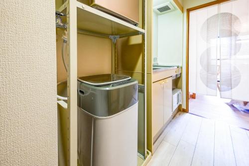 a small kitchen with a trash can in the middle at Japandi 4 Inspired 1BR in Prime City Spot and Near Station in Fukuoka