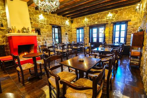 a restaurant with tables and chairs and a fireplace at Varnevo Guesthouse in Ano Trikala