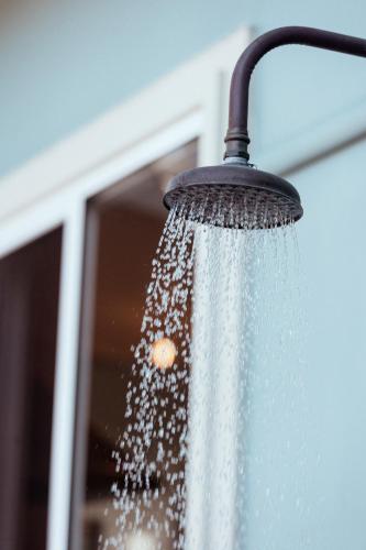 a shower head with water coming out of it at The Blue Beach House - Pet Friendly Coastal Escape in Mollymook in Mollymook