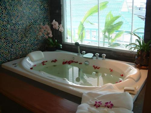a bathroom with a bath tub with flowers in it at Hua Hin Avenue Hotel in Hua Hin
