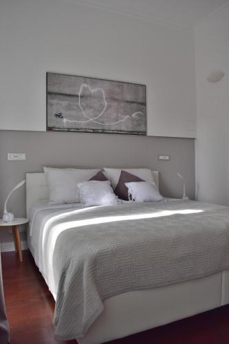 a bedroom with a white bed with a painting above it at Apartment Feel Good in Zagreb