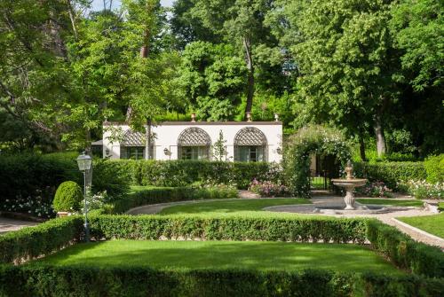 a garden with a white house in the background at Four Seasons Hotel Firenze in Florence