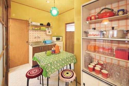eine Küche mit einem Tisch in Grün und Weiß in der Unterkunft Retoro Meieki 2號室 in Nagoya