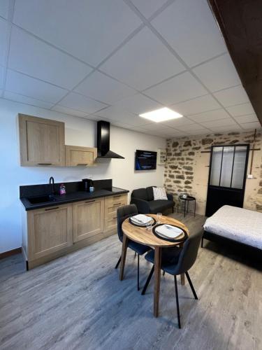 a kitchen and a living room with a table and a couch at Les Pichies, Studio Dadoum, Centre ville in Digoin