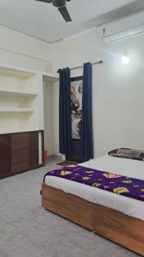 a bedroom with a large bed with blue curtains at Sivahari Homestay in Trivandrum