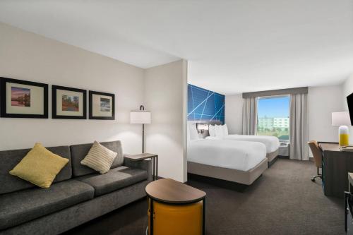 a hotel room with a bed and a couch at Comfort Suites Bentonville - Rogers in Bentonville