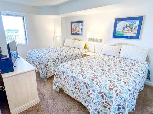 a hotel room with two beds and a television at Verandas 602 in North Myrtle Beach