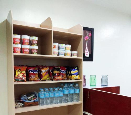 a shelf filled with bottles of water and snacks at Meaco Royal Hotel- ILagan in Ilagan