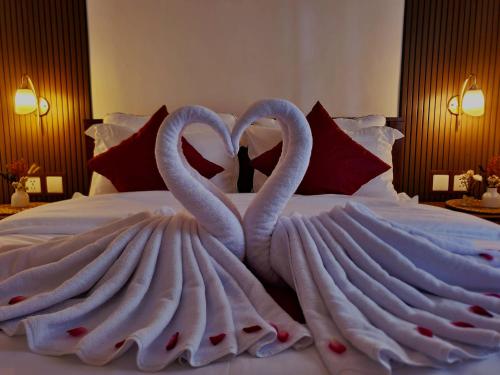 two swans making a heart shape on a bed at GYANA House in Ubud