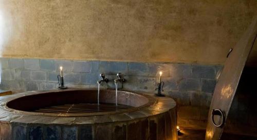 une salle de bain avec un grand lavabo avec deux bougies dans l'établissement Hananoie - A Permaculture Resort, à Astam