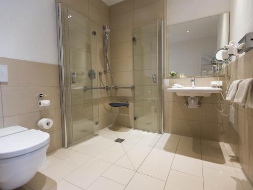 a bathroom with a shower and a toilet and a sink at Hotel Seepark Garni in Überlingen