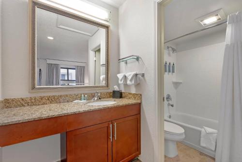 a bathroom with a sink and a toilet and a mirror at MainStay Suites St Louis - Galleria in Richmond Heights