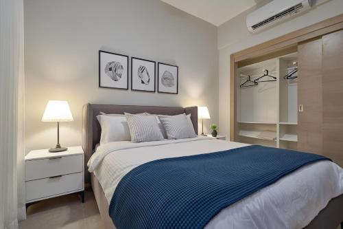 Un dormitorio con una cama grande con una manta azul. en ®{PANO~VIEW~Experience} @DowntownSD PoolGym2BR, en Ensanche Quisqueya