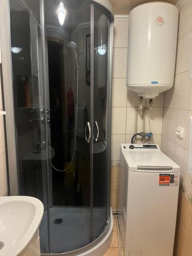 a bathroom with a shower and a toilet and a sink at Котедж "Барвінок" in Verkhovyna