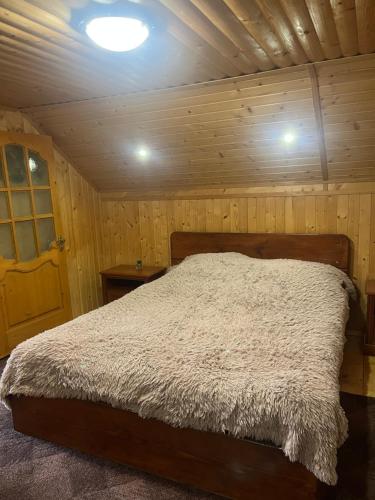a bedroom with a bed in a wooden room at Котедж "Барвінок" in Verkhovyna