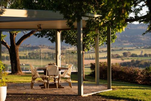 a table and chairs sitting under a gazebo at Allambie - Poolside Elegance in Mudgee Countryside in Mudgee