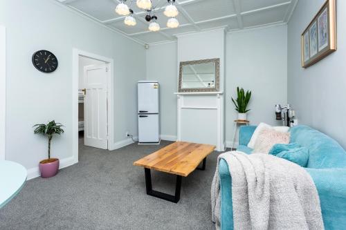 a living room with a blue couch and a table at Central Spot Elegant Home Fresh Features in Auckland