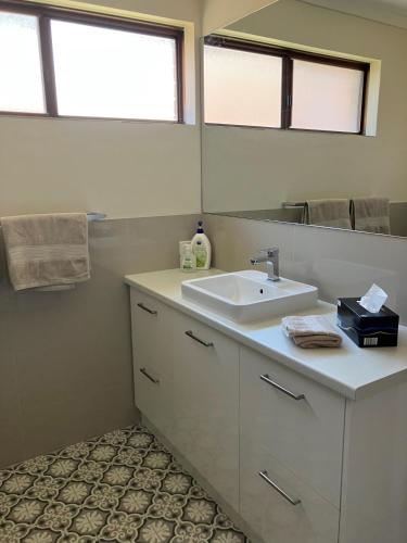 a bathroom with a sink and a mirror at Seaview on Kent in Rockingham