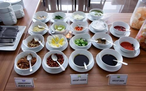 a table with bowls and plates of food on it at Asoka Luxury Hotel in Tanjungkarang