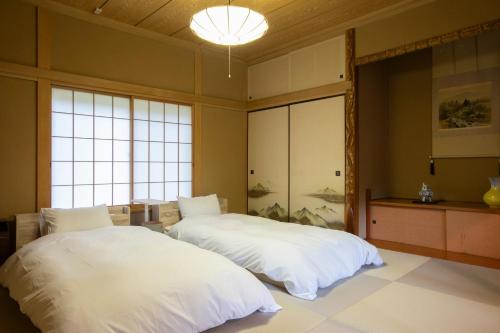 two beds in a large room with windows at rinne 2nd living Nasu Forest in Wada