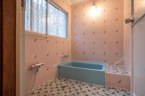a bathroom with a blue tub in the corner at rinne 2nd living Nasu Forest in Wada