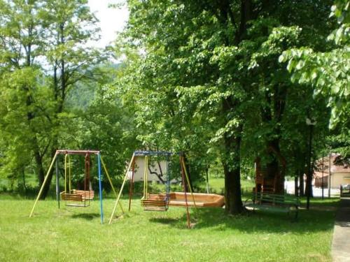 two swings in a park next to a tree at Hotel Perfect in Yamna