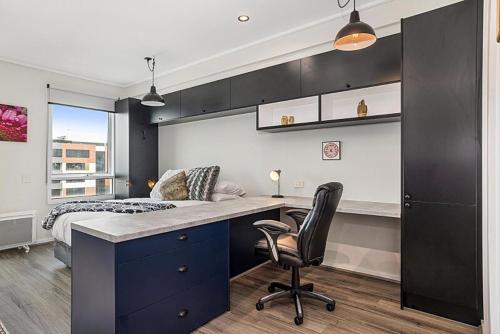 a bedroom with a bed and a desk with a chair at Studio Apartment near CBD, RMIT & Uni of Melbourne in Melbourne