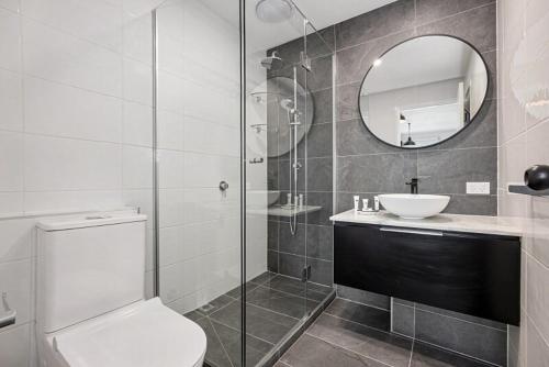 a bathroom with a toilet and a sink and a mirror at Studio Apartment near CBD, RMIT & Uni of Melbourne in Melbourne