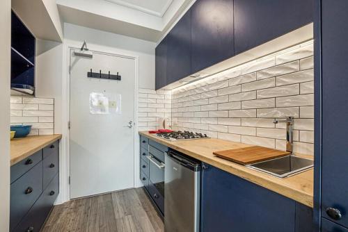 a kitchen with blue cabinets and a counter top at Studio Apartment near CBD, RMIT & Uni of Melbourne in Melbourne