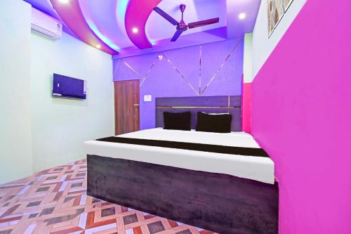 a bedroom with a large bed in a pink room at Hotel O Star Mall Kolkata Formerly Dreamland in Dohāri