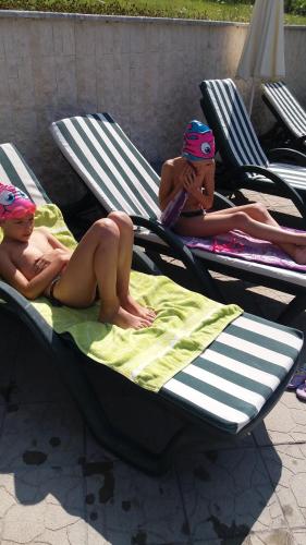 two naked babies laying on chaise lounges on beach chairs at Hotel Perfect in Yamna