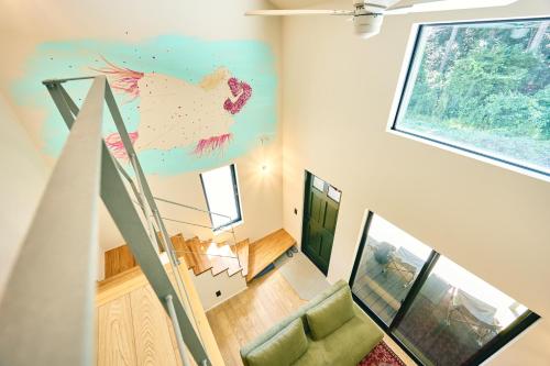 a staircase with a painting of a chicken on the wall at Neverland Garden A棟 - 山の中の別荘一棟貸切 in Ichigaya