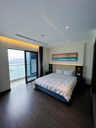 a bedroom with a large bed and a large window at Sapphire home S2 in Ha Long