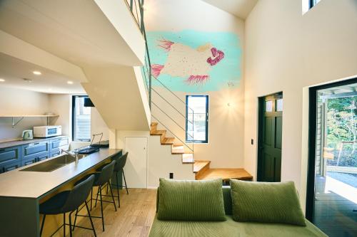 a staircase in a house with a green couch at Neverland Garden A棟 - 山の中の別荘一棟貸切 in Ichigaya
