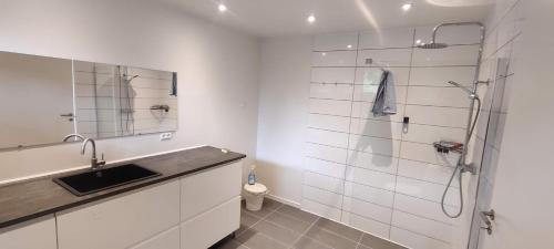 a white bathroom with a shower and a sink at House in Ølst, Randers SV in Randers