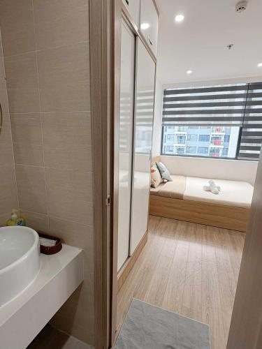 a bathroom with a sink and a bed and a window at Thương Apartment 2 in Thôn Văn Dương