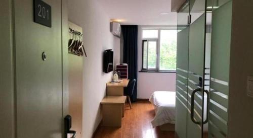 a small room with a bed and a window at 7 Days Inn Tianjin Ancient Cultural Street Jinshiqiao Metro Station in Tianjin