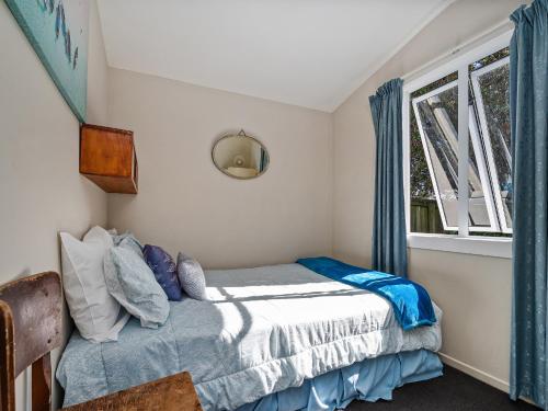 une chambre avec un lit et une fenêtre dans l'établissement Caddy's Shack - Whangamata Holiday Home, à Hauturu