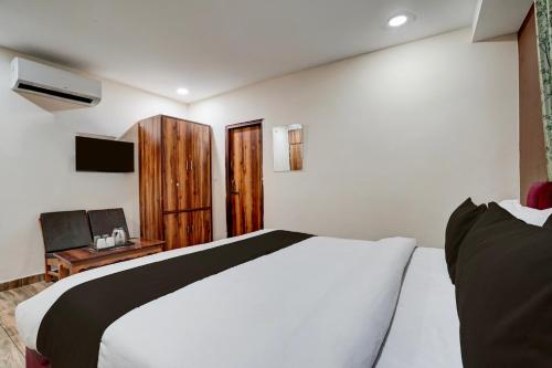 a bedroom with a bed and a desk with a television at Hotel O 3 Bros in Sohāna