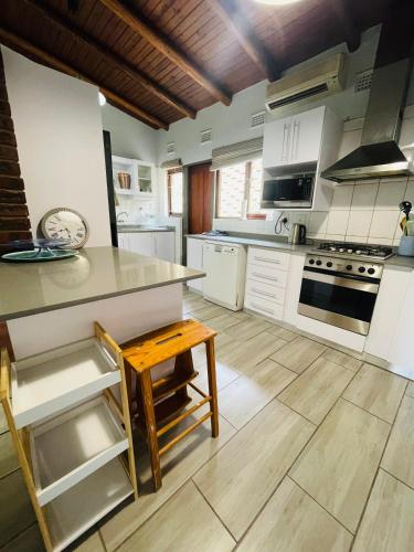 a kitchen with white appliances and a wooden floor at 4 Bedroom Beach House on 4th Ave in Umdloti