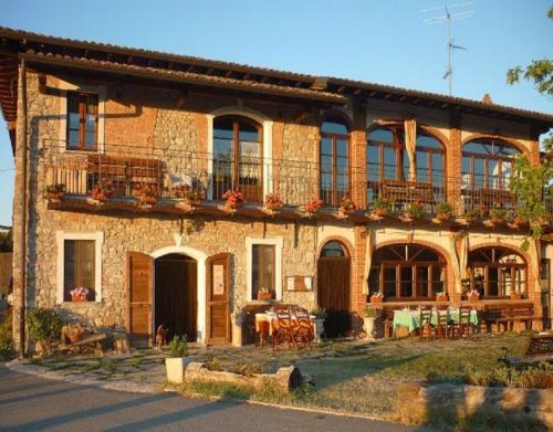 a large brick building with a balcony and tables at Ca Dell'Aglio in Momperone